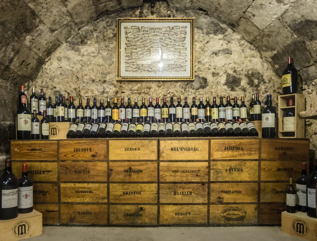 A rustic wine cellar featuring a display of assorted wine bottles on stacked wooden crates, symbolizing the variety and tradition of winemaking—perfect inspiration for beginners exploring home wine kits.