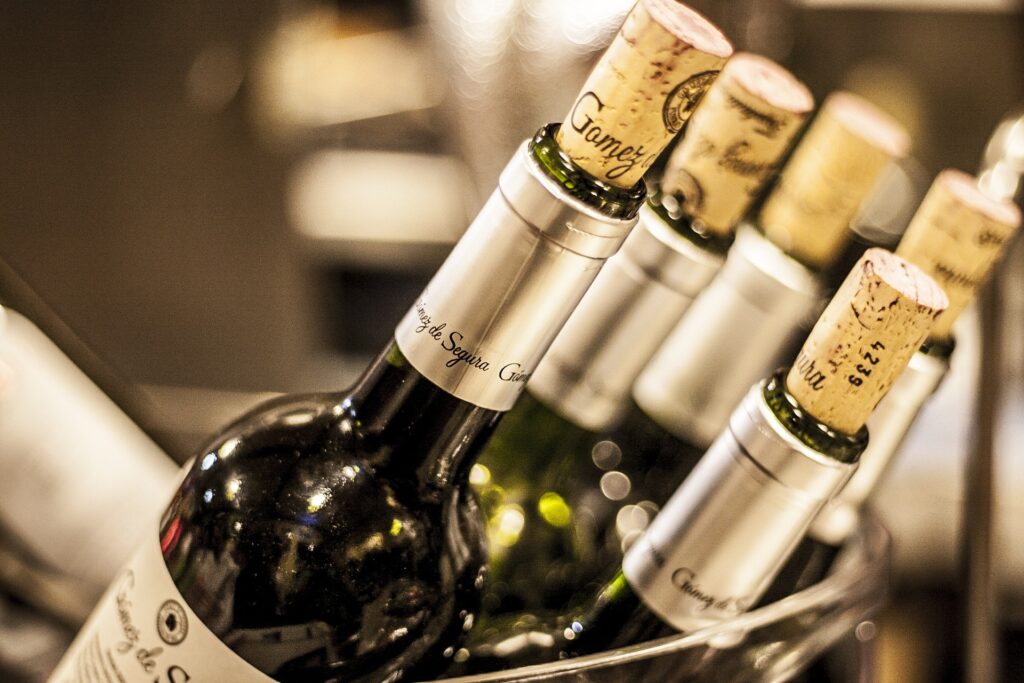 A close-up view of corked wine bottles in an ice bucket, perfect for a blind wine tasting party.