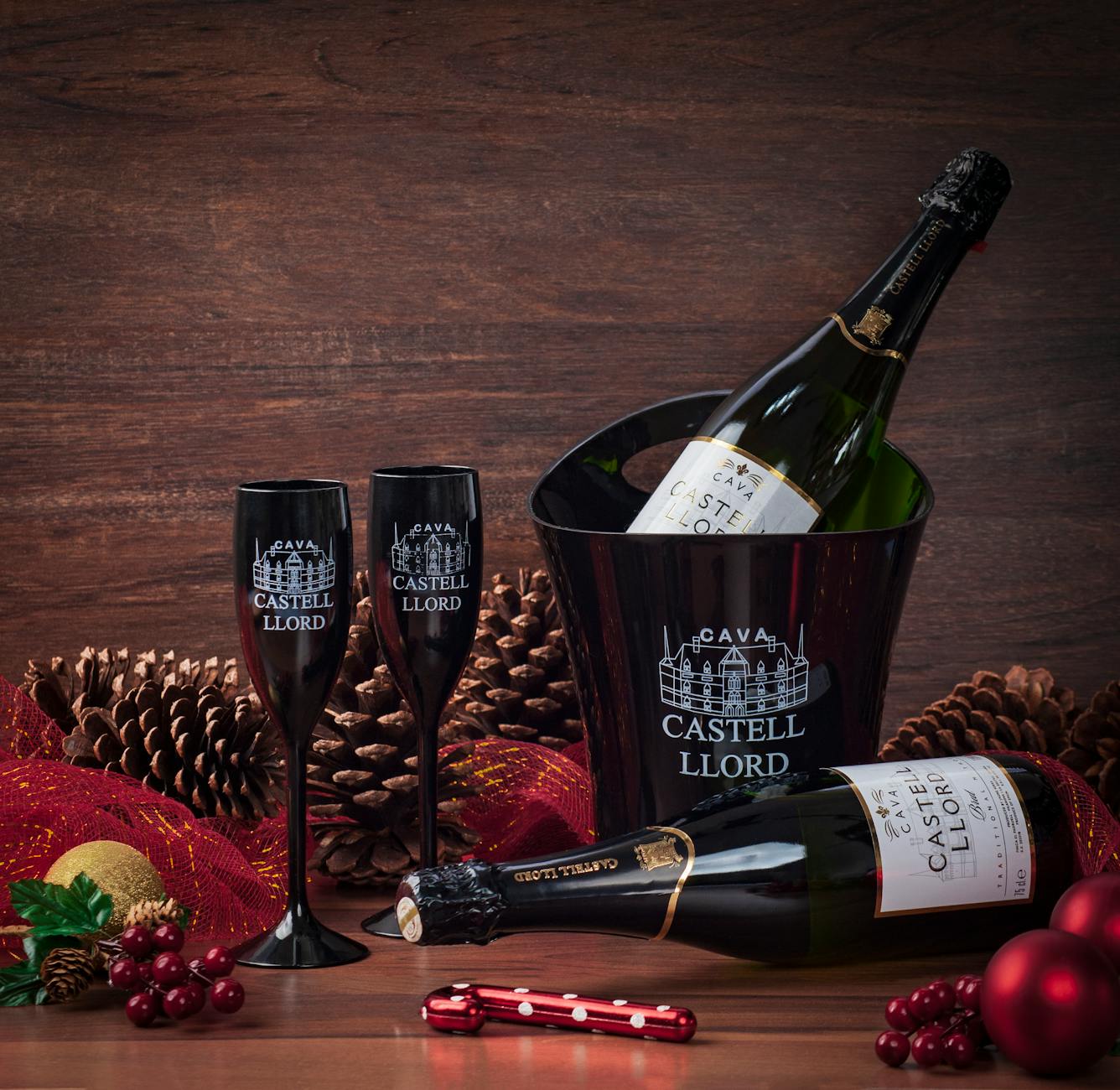 Cava Castell Llord sparkling wine in a black ice bucket with glasses and holiday decor