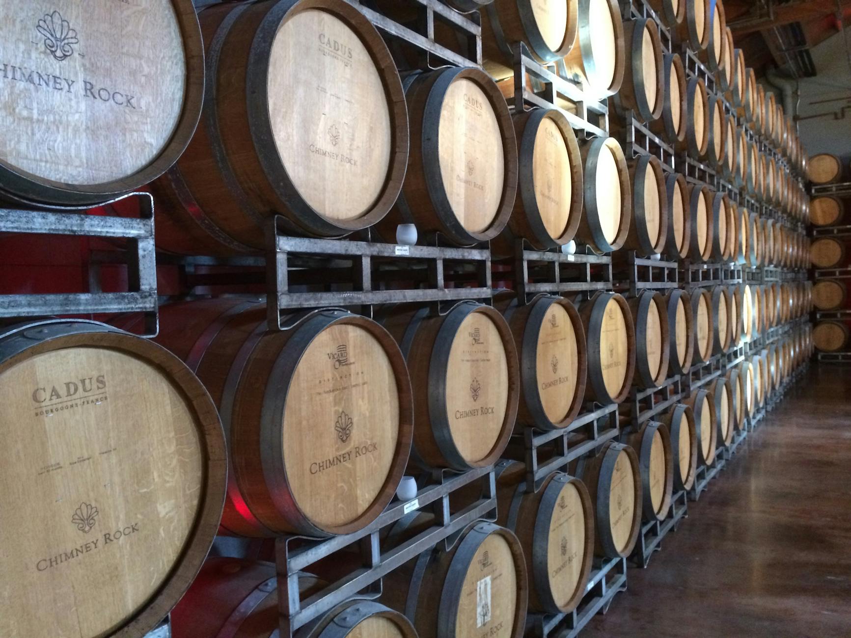 Rows of oak wine barrels at Chimney Rock Winery representing California winemaking tradition.